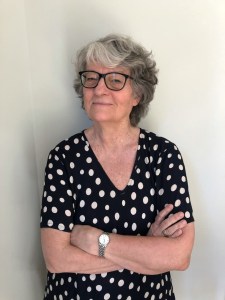 Annika Ström Melin står med armarna i kors. Hon har en svart vitprickig topp på sig.